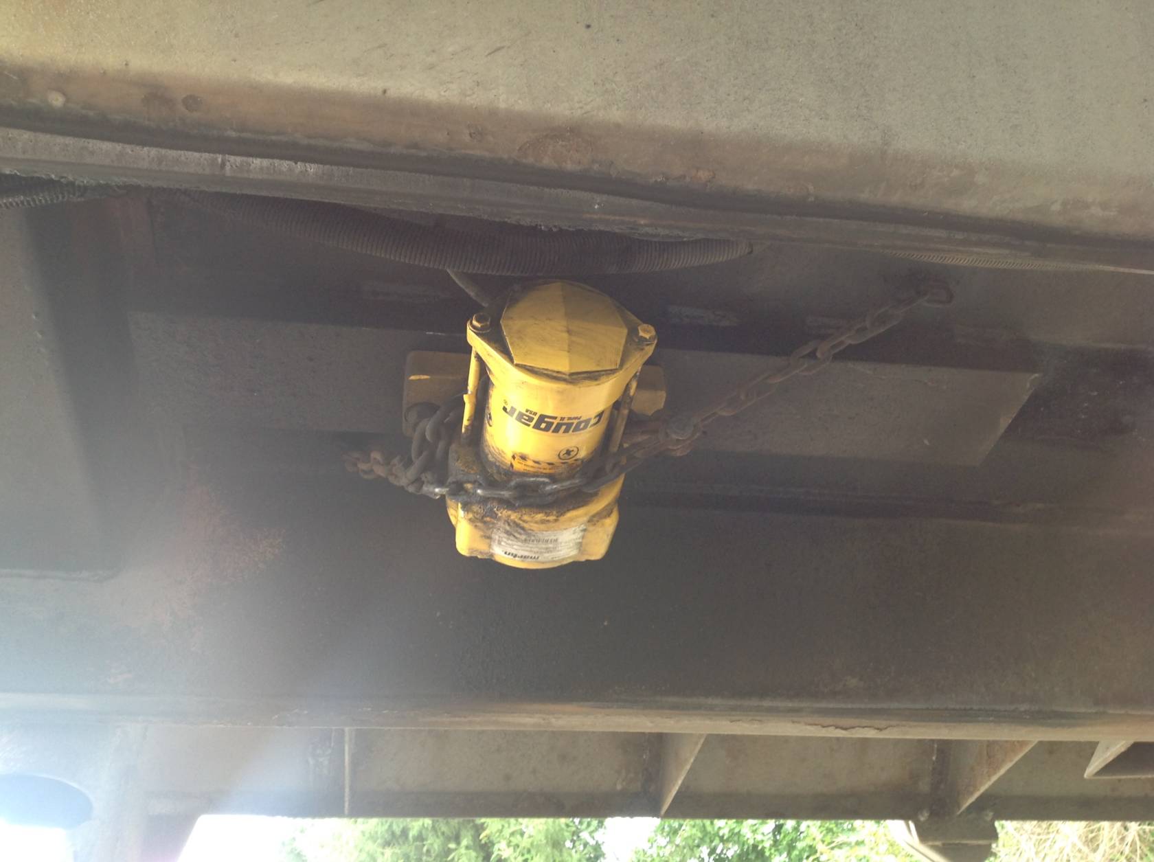 The unit is mounted to the frame and secured by a safety chain.